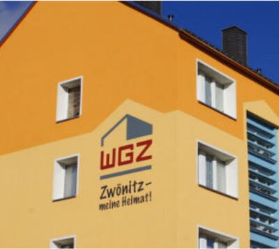 Orangefarbene Hausfassade mit Logo und Schriftzug der WGZ Zwönitz – meine Heimat